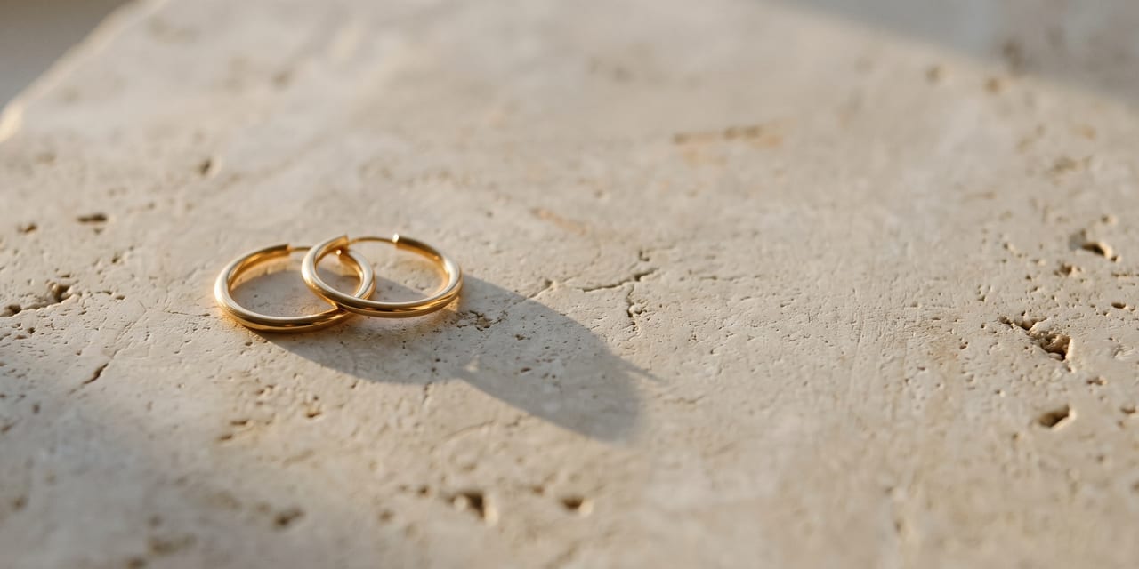Gold earrings on a stone surface